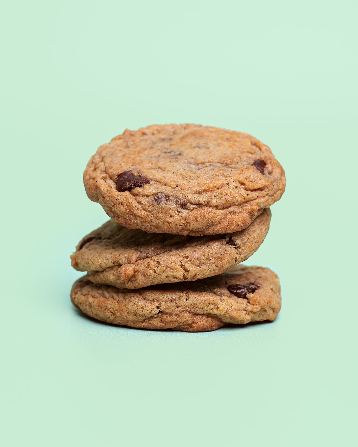 Close-up of a Banana Chocolate Chip Cookie with golden crispy edges, a soft chewy center, and melty chocolate chips throughout.