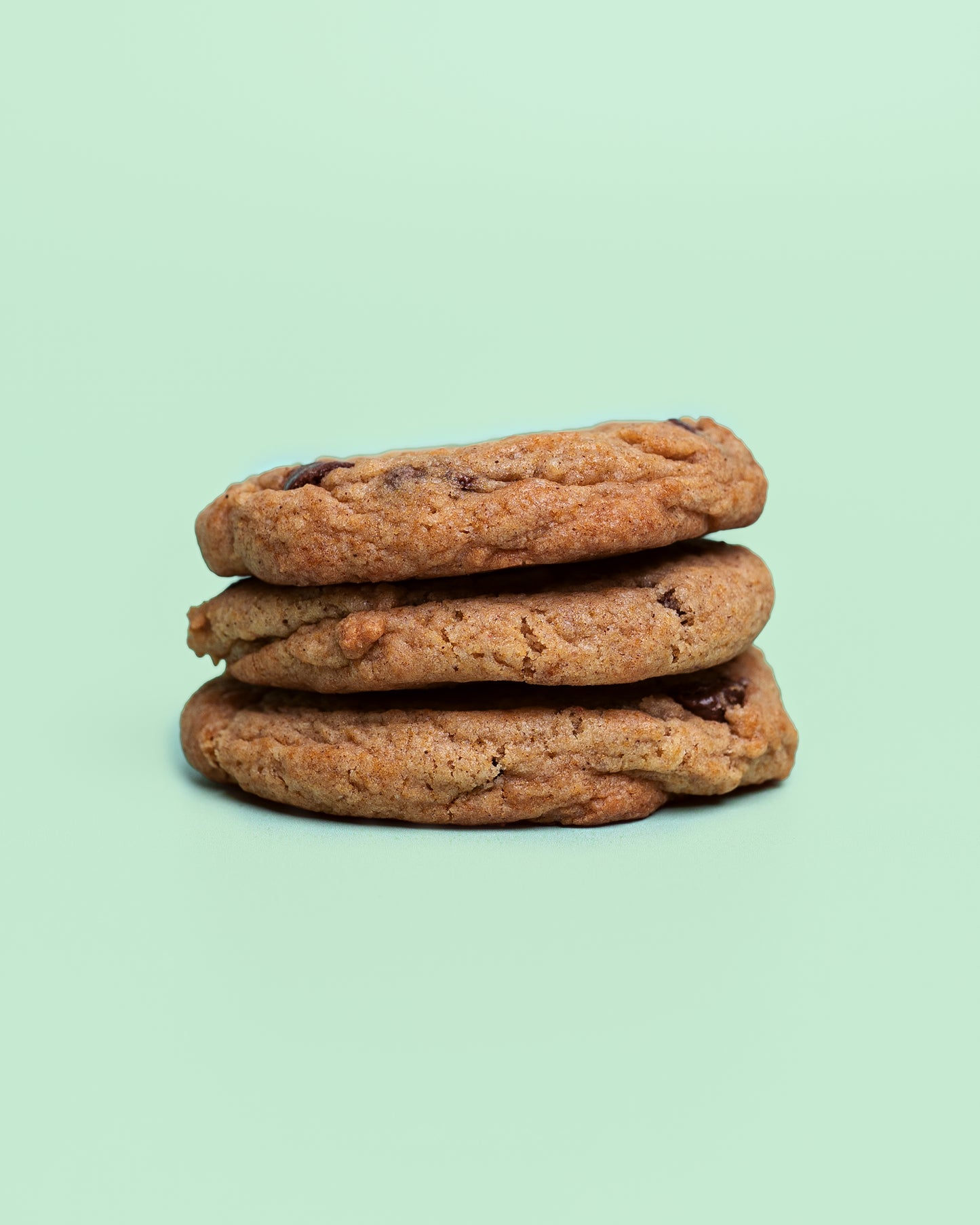 Close-up of a Banana Chocolate Chip Cookie with golden crispy edges, a soft chewy center, and melty chocolate chips throughout.