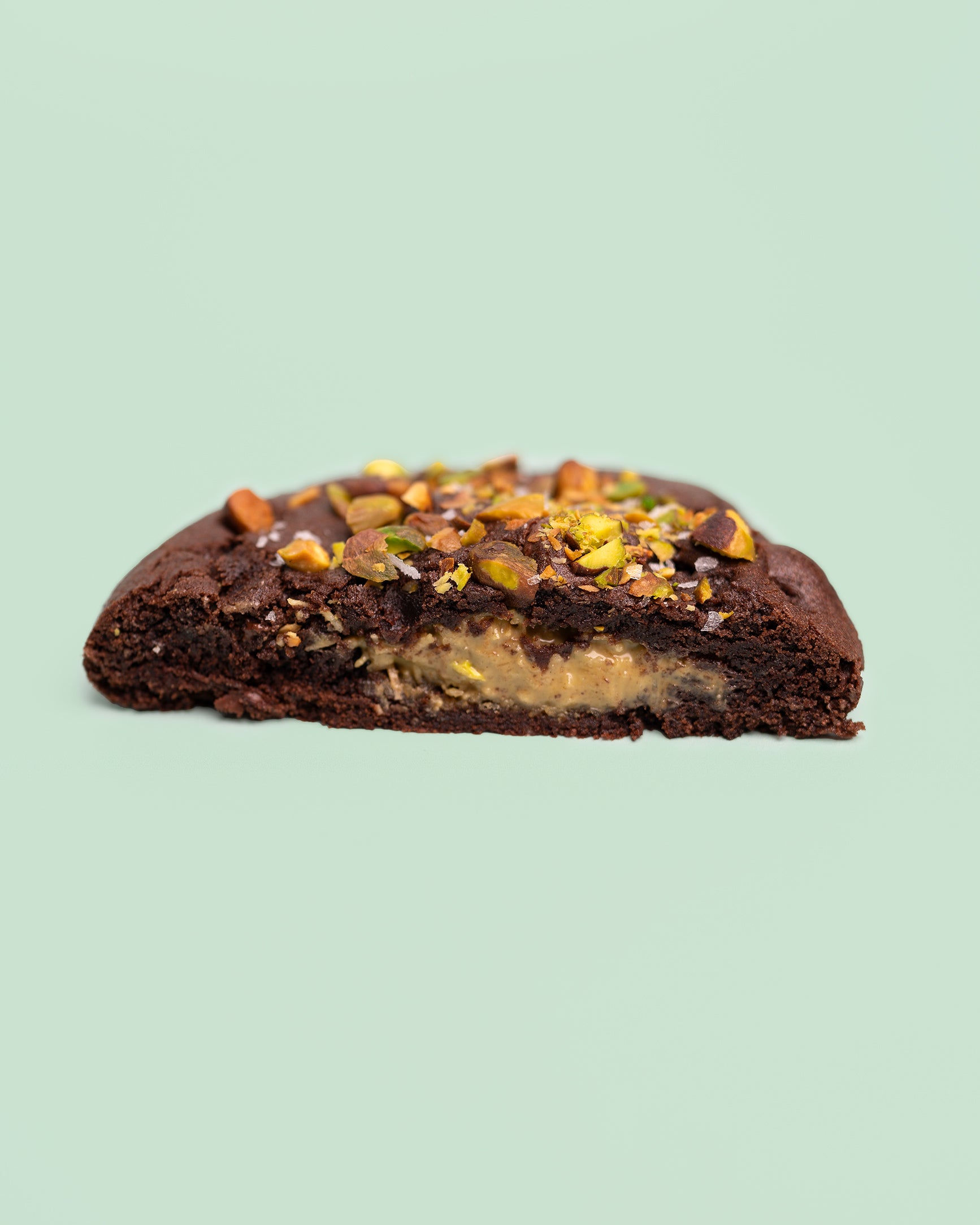 Dubai Chocolate Cookie with a rich, chocolatey exterior, crisp edges, and a soft, fudgy center, filled with crispy Kataifi, creamy Pistachio Butter, and smooth Tahini.
