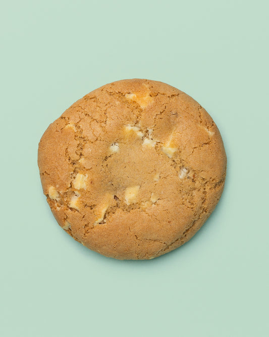 Close-up image of a Stuffed Biscoff Cookie with a golden-brown exterior, cracked top, and creamy Biscoff spread oozing from the center.