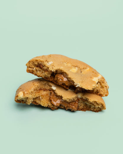 Close-up image of a Stuffed Biscoff Cookie with a golden-brown exterior, cracked top, and creamy Biscoff spread oozing from the center.